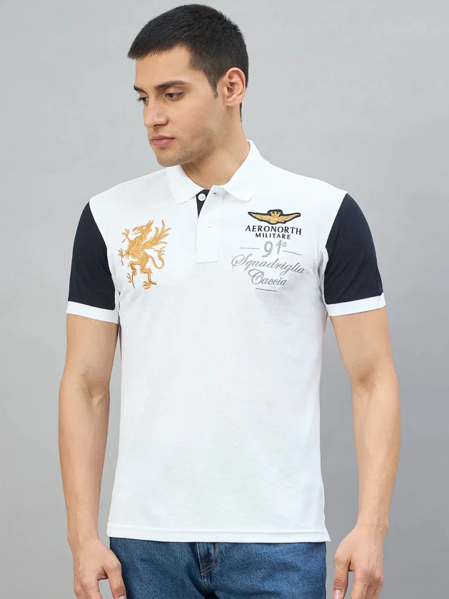 Man wears 98degreenorth Men's White Black Sleeve Aeronorth 91ª Polo T-Shirt, standing by a plain gray background.