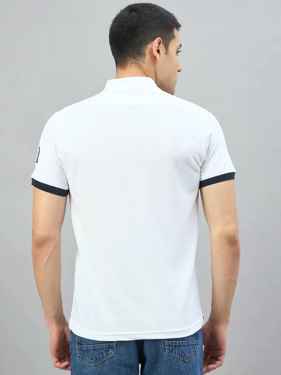A man in a 98degreenorth Men's White Embroidered Polo T-Shirt and jeans stands with his back to the camera.