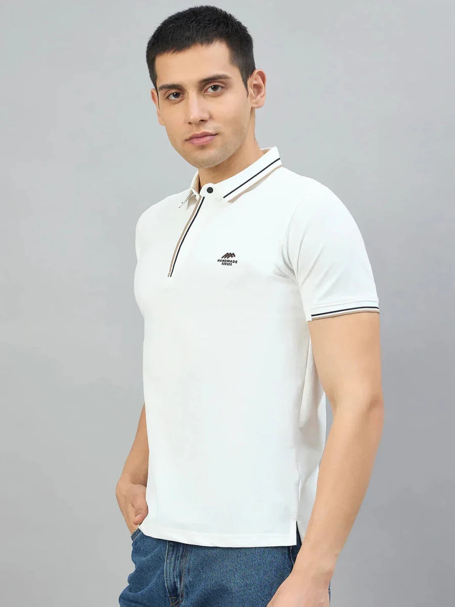 Man wears 98degreenorth Men's White Polo T-Shirt—Handmade Series with contrast tipping, against a grey background.