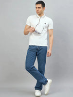 Man in 98degreenorth Men's White Polo T-Shirt — Handmade Series with contrast tipping, jeans, and sneakers on grey background.
