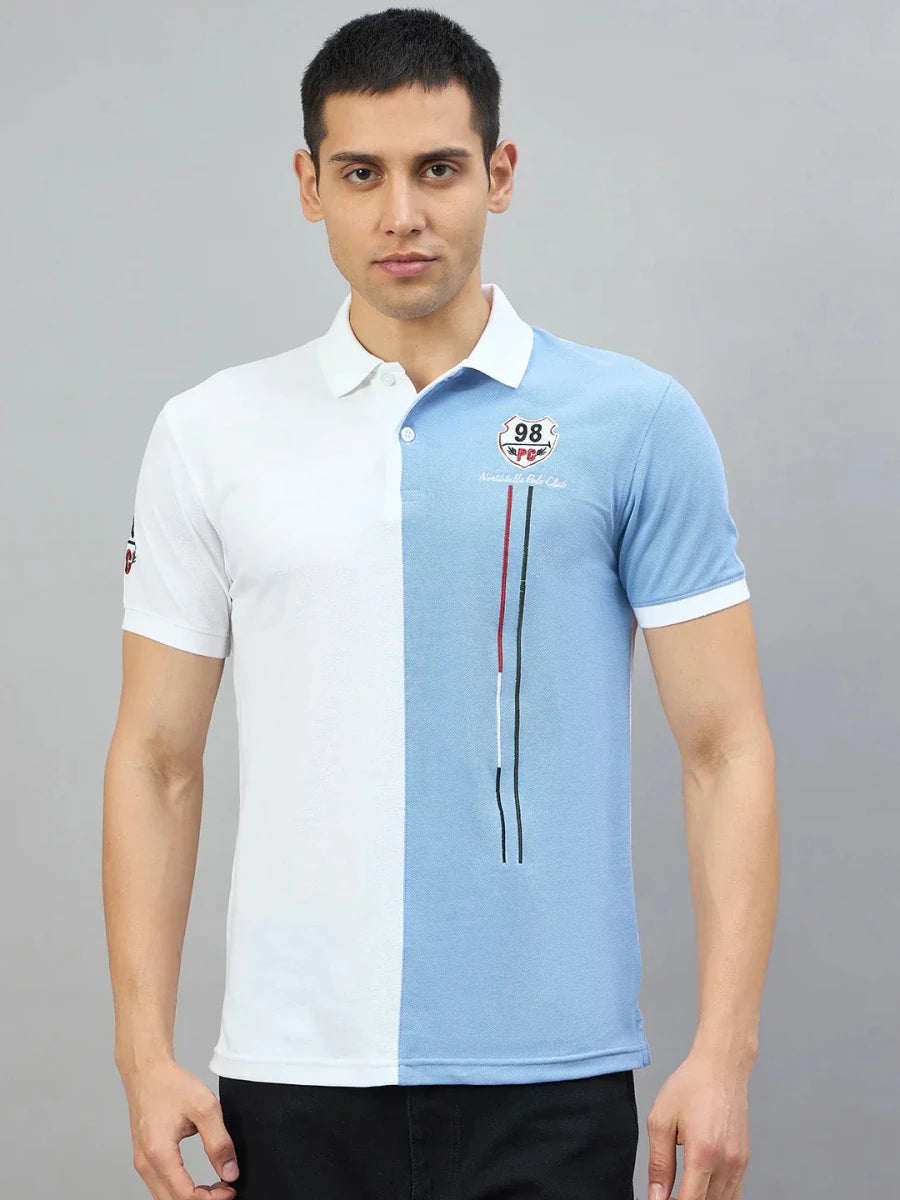 Man wears a 98degreenorth Men's White Sky Blue Colour Block Polo T-Shirt with black pants, against a gray background.