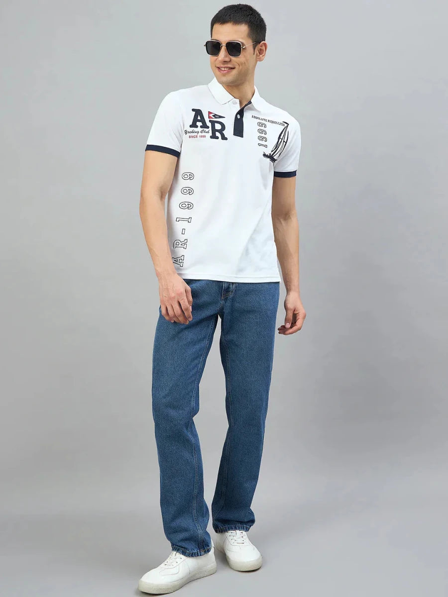Man in 98degreenorth Men's White Yachting Club Polo T-Shirt, sunglasses, blue jeans & white sneakers, standing and smiling.