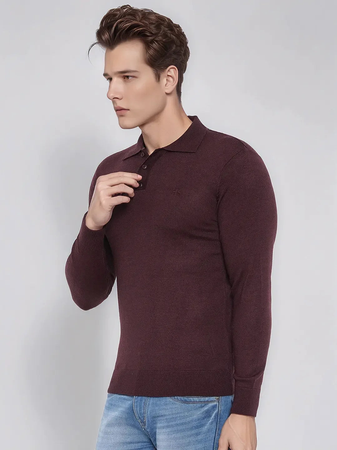 Man wears 98degreenorth Men’s Wine Merino Wool Polo Neck Sweater with blue jeans against a plain light background.