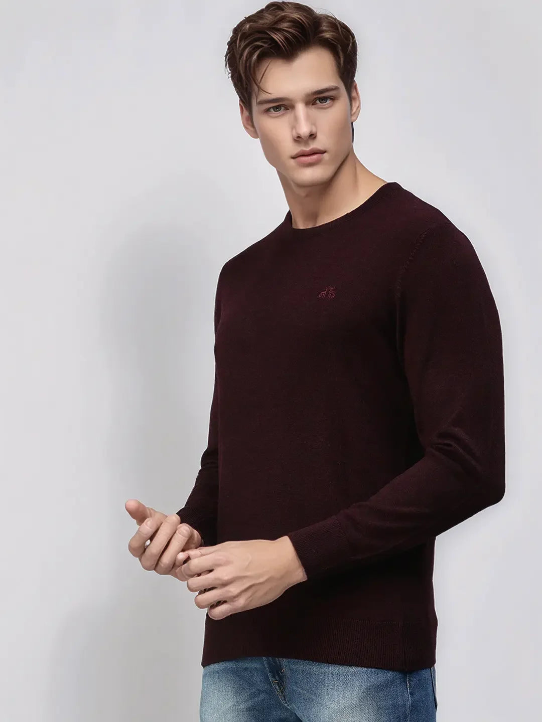 Man in 98degreenorth Men’s Wine Merino Wool Round Neck Sweater and blue jeans, standing against a plain light background.