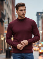 A man in a 98degreenorth Men’s Wine Merino Wool Turtle Neck stands on a city street with blurred lights behind him.
