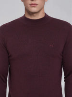 A man wears a 98degreenorth Men’s Wine Merino Wool Turtle Neck Sweater with a small chest logo in India.