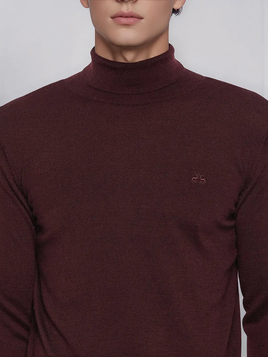 Man in a Men’s Wine Merino Wool Turtle Neck Sweater by 98degreenorth, facing the camera.