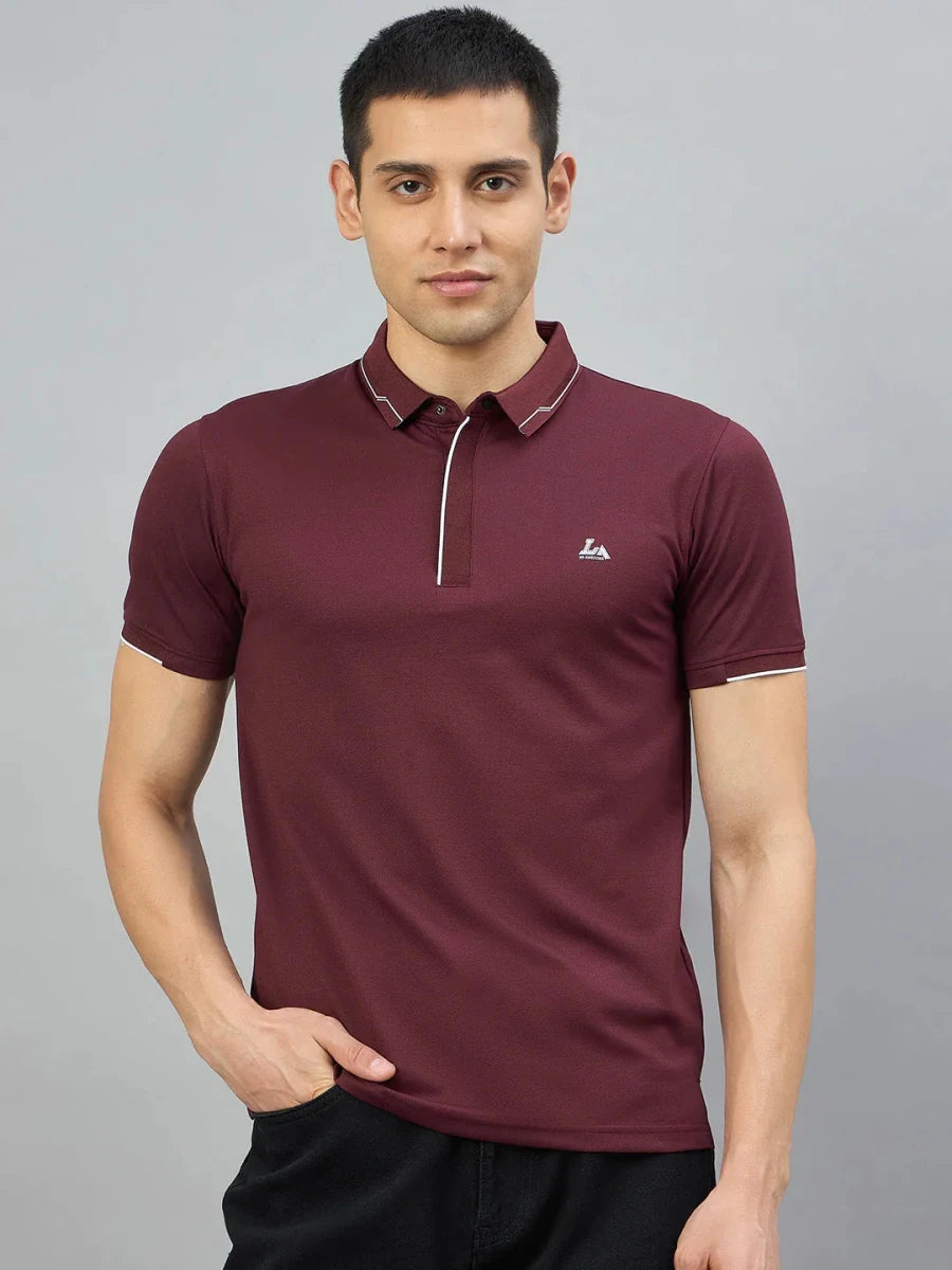 Man models 98degreenorth Men's Wine Polo T-Shirt with white tipping & LA logo, hand in pocket, gray background.