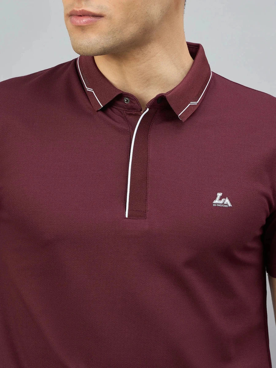 A man wears the 98degreenorth Men's Wine Polo T-Shirt with white tipping and an LA logo.