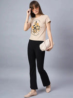 Woman in sunglasses, black pants, loafers, and 98degreenorth Minimal Typography Print Cotton Tee, holding beige clutch.