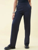 Person wearing 98degreenorth Luxe Lounge Navy Wide Leg Pintuck Trackpants, black top, and bracelets against a light background.