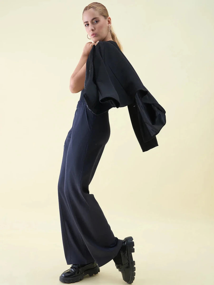 Woman in Navy Wide Leg Pintuck Trackpants by 98degreenorth poses against a light background.