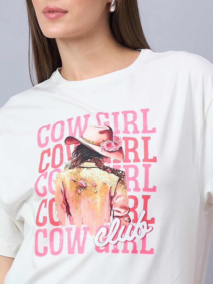 A woman wears a 98degreenorth Offwhite Graphic Cotton Tee with COWGIRL CLUB, streetwear drop shoulder style.