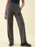 Model wears 98degreenorth Olive Wide Leg Pintuck Trackpants with black shoes and bracelets against a plain light background.