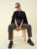 Woman in sunglasses and black jacket styles 98degreenorth Olive Wide Leg Pintuck Trackpants from Luxe Lounge.