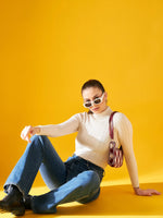 A woman sits on the floor against a bright yellow background, wearing white sunglasses, blue jeans, black boots, and a Ribbed Offwhite Turtle Neck Pullover by 98degreenorth with a small checkered shoulder bag. She looks confidently at the camera.