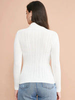A woman with long brown hair, wearing the 98degreenorth Ribbed White Turtle Neck Pullover and blue jeans, stands with her back to the camera against a beige background.