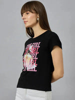 Woman in a black 98degreenorth round-neck cotton t-shirt with pink COWGIRL CLUB graphic, wearing white pants.