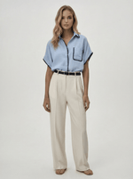 Woman in a Sky Blue Whipstitch Trim Cotton Shirt and beige trousers from 98degreenorth’s Luxe Summer collection.