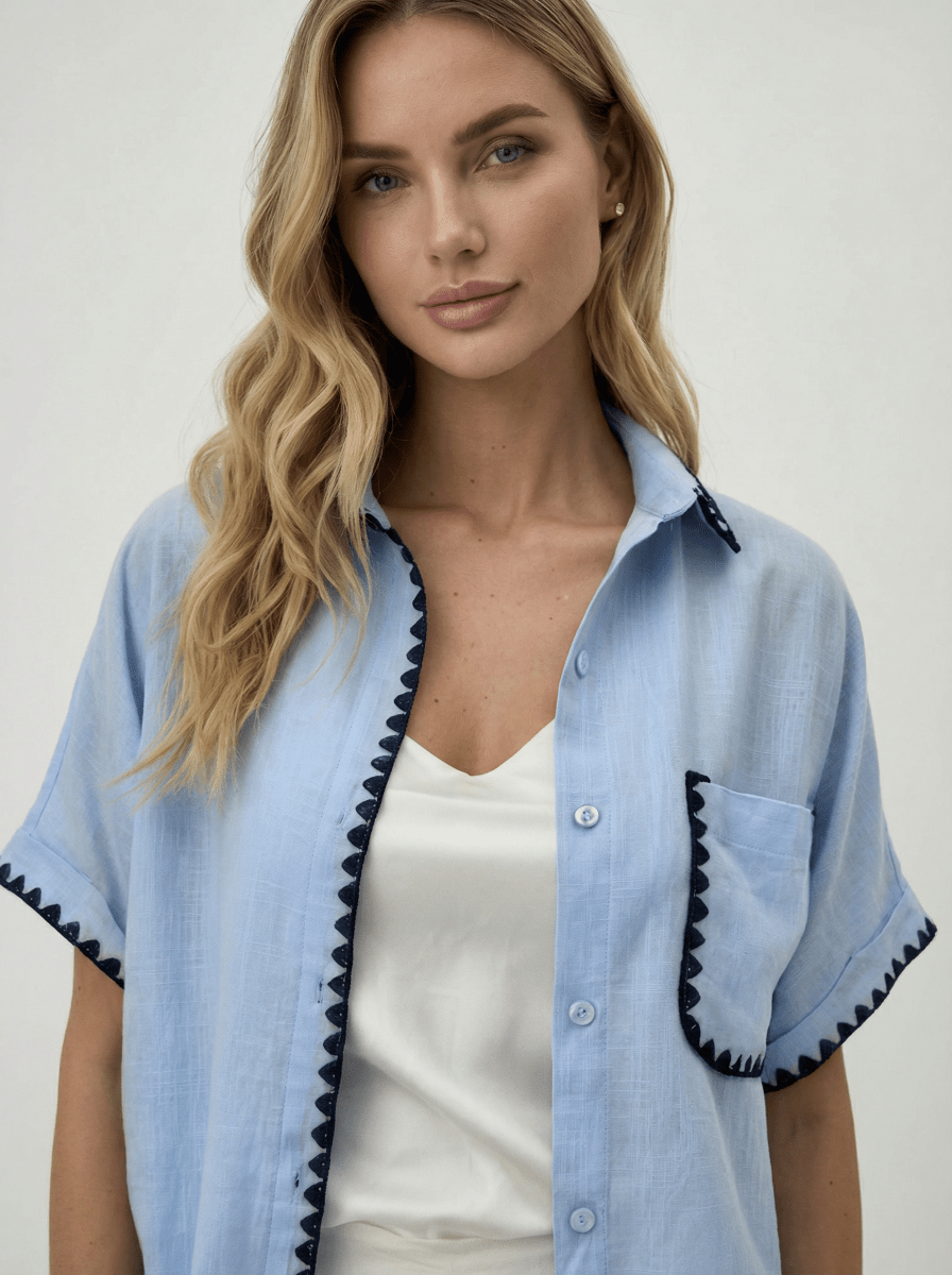 Woman with long blonde hair wears a Sky Blue Whipstitch Trim Cotton Shirt by 98degreenorth, Luxe Summer collection.