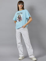 Woman in 98degreenorth Soft Cotton Typography Printed Tee with drop shoulder sleeves poses in white pants and sneakers.