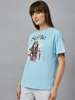 Woman in a 98degreenorth Soft Cotton Typography Printed Tee, drop shoulder sleeves, urban style on a gray background.