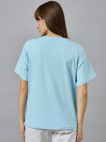 Woman with straight brown hair in a 98degreenorth Soft Cotton Typography Printed Tee, urban style, facing away.
