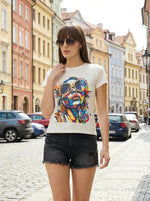Woman in a 98degreenorth stylish typography cotton tee strolls a vibrant cobblestone street in casual streetwear.