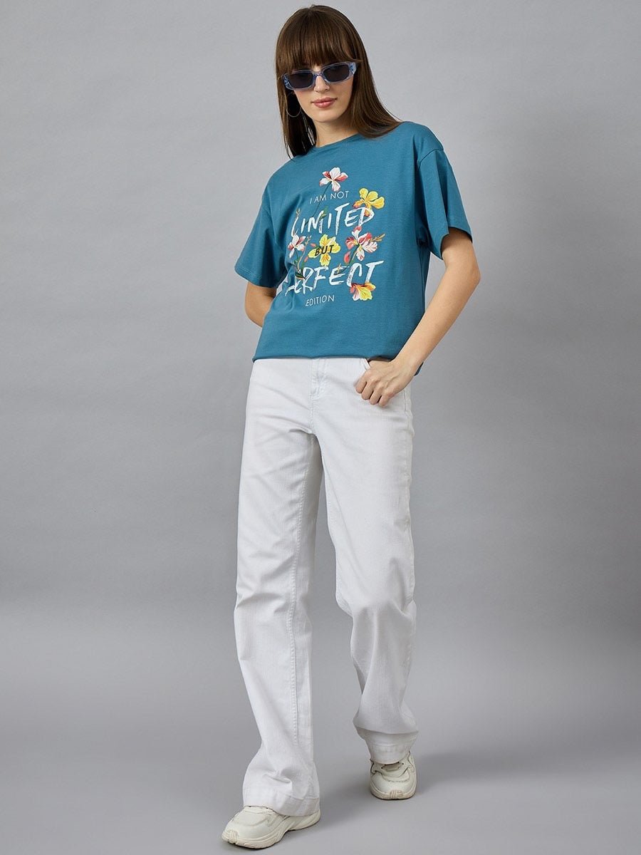 Woman in sunglasses wears 98degreenorths Stylish Typography Printed T-shirt, white pants, and sneakers.