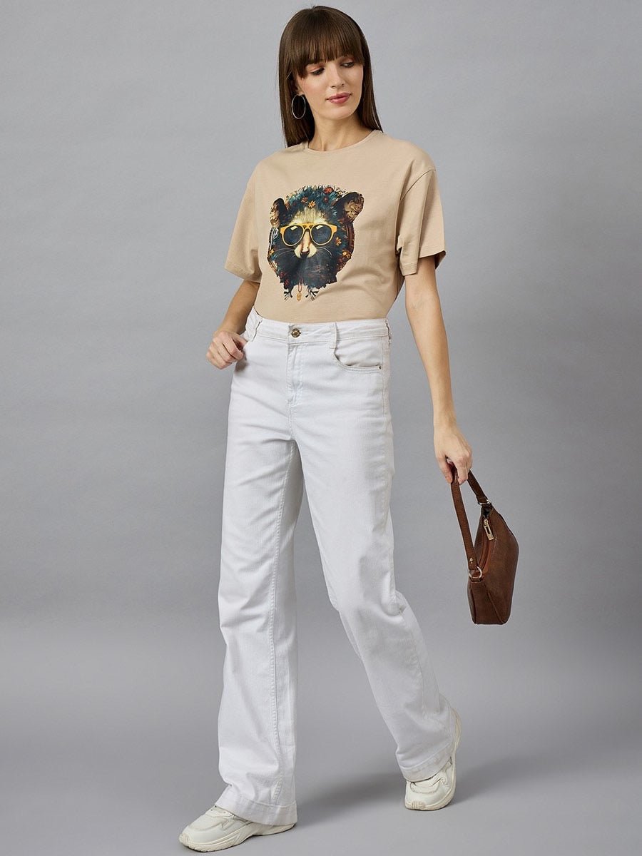 Woman wears 98degreenorths Trendy Typography Oversized Cotton T-shirt, white jeans, and sneakers for streetwear chic.