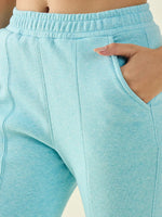 A person wears 98degreenorth Turquoise Blue Women’s Fleece Bootcut Sweatpants, hand in pocket.