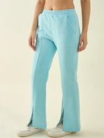 A person in 98degreenorth Turquoise Blue Women’s Fleece Bootcut Sweatpants and white sneakers, against a plain background.