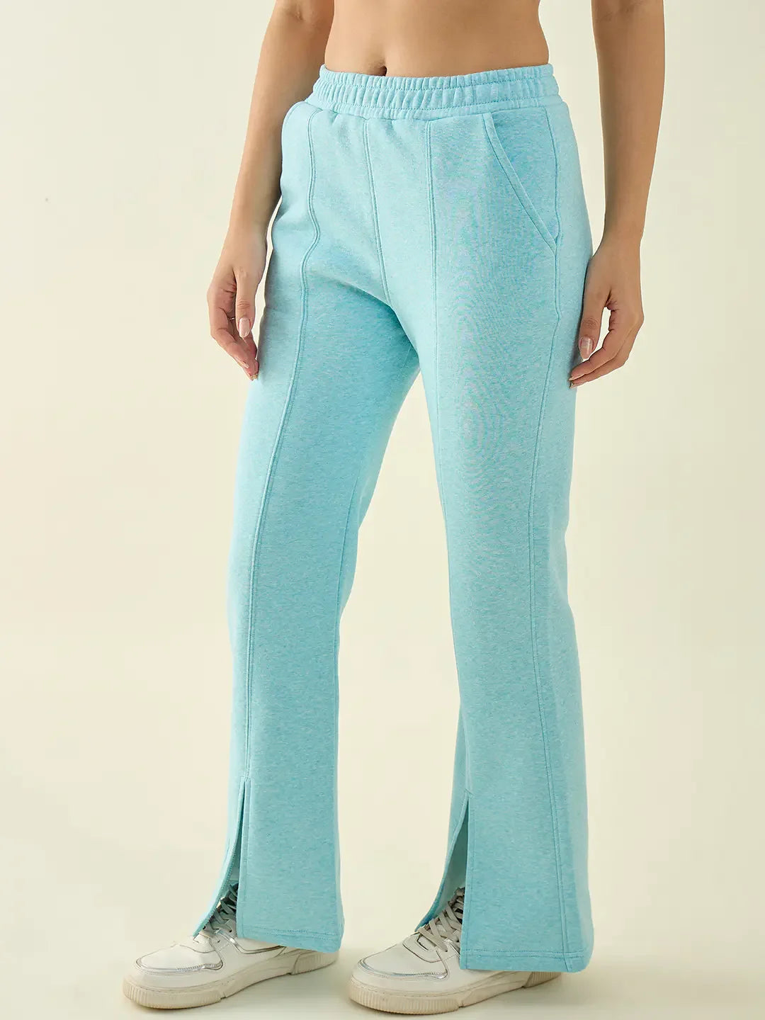 A person in 98degreenorth Turquoise Blue Women’s Fleece Bootcut Sweatpants and white sneakers, against a plain background.