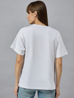 Woman with straight brown hair in a 98degreenorth Relax Fit Cotton Typography Graphic T-shirt and blue jeans, facing away.