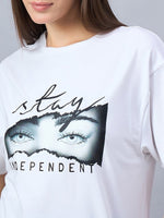 A woman wears a 98degreenorth Typography Print Drop Shoulder T-shirt, soft cotton streetwear with eye graphics.