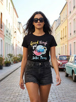 Woman in 98degreenorth's cotton round-neck typography tee walks a vibrant city street lined with vintage cars.