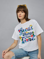 Woman in a 98degreenorth Urban Streetwear Typography T-shirt sits on a stool, ideal for casual office wear.