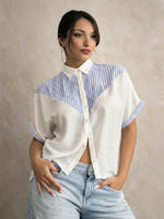 Woman in 98degreenorth White Blue Colour Block Cotton Shirt, Luxe Summer, standing against a beige textured background.