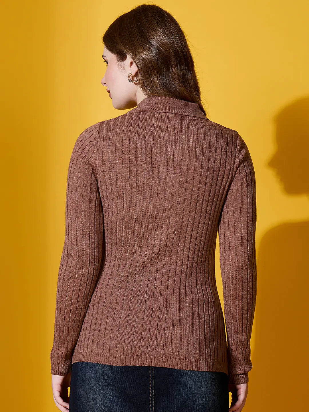 Woman in 98degreenorth Camel Ribbed Collar Sweater, handcrafted winterwear, stands against a yellow background.