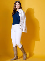 Woman in 98degreenorth cobalt blue ribbed knit collar sweater stands smiling against a yellow background.