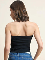 Woman with wavy brown hair in a 98degreenorth Women Cotton Black Crop Tube Top and blue jeans, shown from the back.