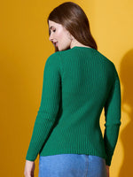 Woman in 98degreenorth Emerald Green Ribbed Sweater and blue jeans, standing against a yellow background.