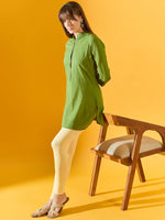 Woman in 98degreenorth Women Lemon Ankle-Length Leggings stands by a wooden chair against a yellow backdrop.