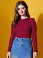A woman wears the 98degreenorth maroon ribbed sweater with a denim skirt, standing against a yellow background.