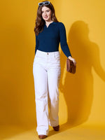 Woman in a 98degreenorth Midnight Blue Ribbed Collar Neck Sweater stands before a yellow background.