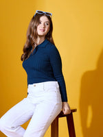 Woman models 98degreenorth’s midnight blue ribbed collar sweater, a premium winter layer, against a yellow backdrop.
