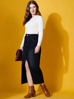 Woman in a 98degreenorth Off White Ribbed Sweater, holding a clutch against a yellow background.