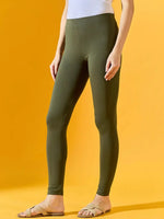 Woman wearing 98degreenorth Women Olive Ankle-Length Leggings with a white top and sandals, against a yellow background.