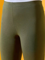 Close-up of 98degreenorth Women Olive Ankle-Length Leggings in stretchable cotton spandex against a yellow backdrop.