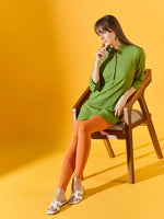 A woman in 98degreenorth Women Orange Ankle-Length Leggings sits on a wooden chair against a yellow background.